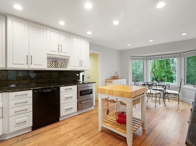 kitchen featuring decorative backsplash, light hardwood / wood-style flooring, black dishwasher, white cabinetry, and stainless steel microwave