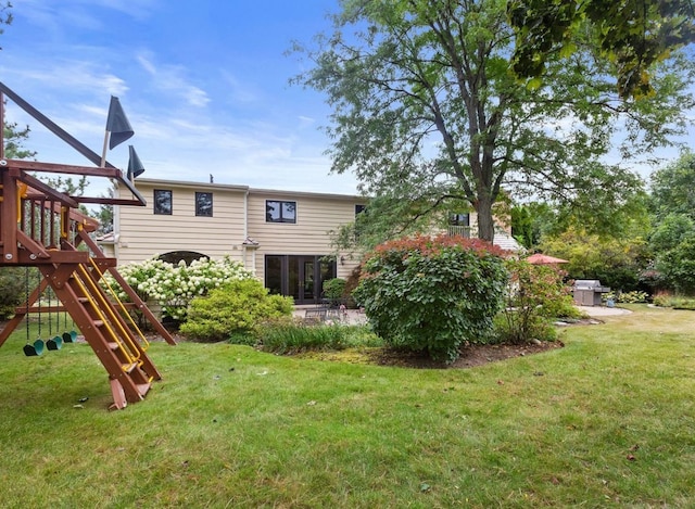 rear view of property with a patio, a playground, and a lawn