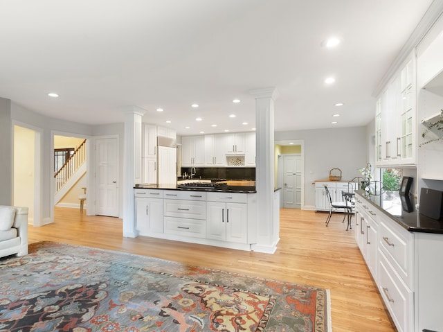 kitchen with tasteful backsplash, light hardwood / wood-style flooring, and white cabinets