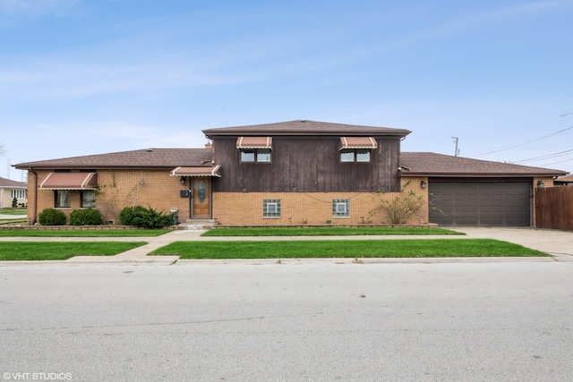 tri-level home with a garage and a front lawn