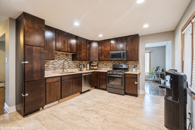 kitchen featuring backsplash, sink, dark brown cabinets, and appliances with stainless steel finishes