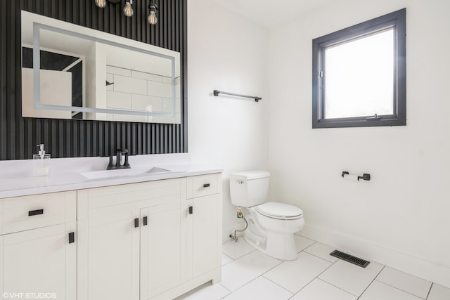 bathroom with toilet, vanity, and tile patterned floors