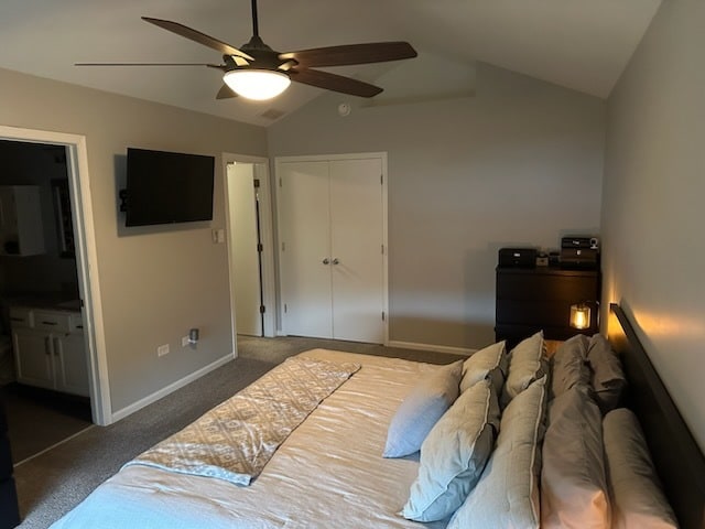 carpeted bedroom with connected bathroom, a closet, ceiling fan, and lofted ceiling