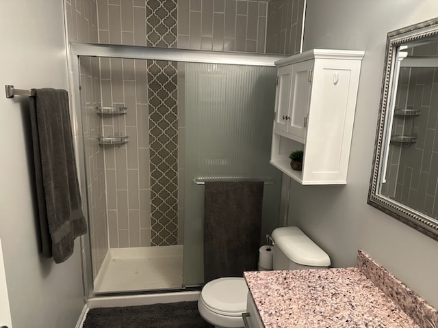 bathroom with vanity, an enclosed shower, and toilet