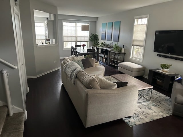 living room featuring dark hardwood / wood-style floors and a healthy amount of sunlight