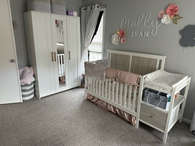 bedroom with a crib and carpet