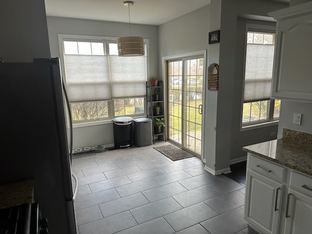 doorway featuring light tile patterned flooring and a wealth of natural light