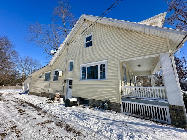 snow covered rear of property with a porch