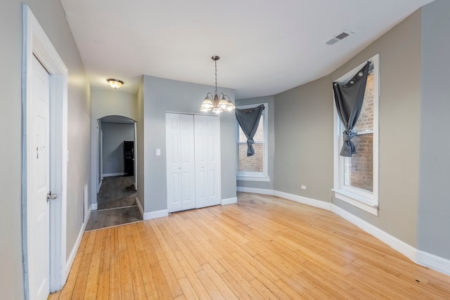 spare room with a chandelier and light hardwood / wood-style flooring