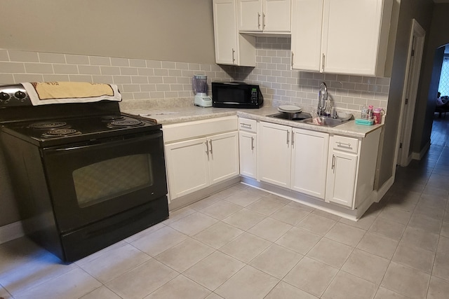 kitchen with white cabinetry, sink, light stone countertops, backsplash, and black appliances