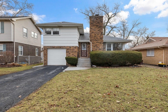 split level home with brick siding, aphalt driveway, a front yard, a chimney, and a garage