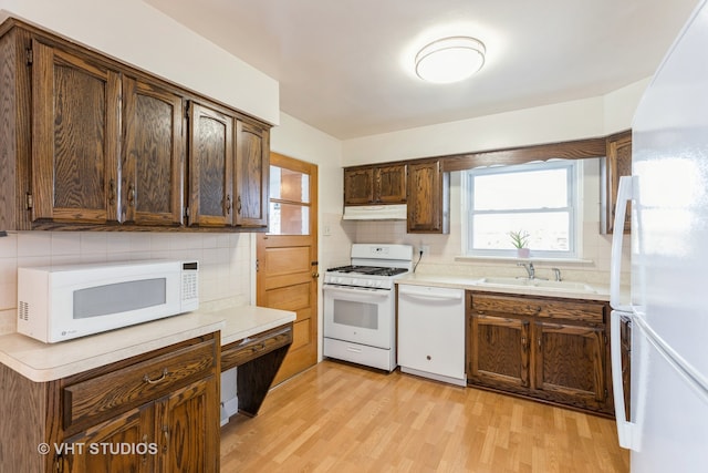 kitchen with decorative backsplash, light hardwood / wood-style floors, white appliances, and sink