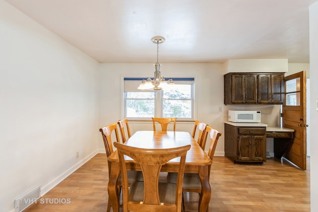 dining room featuring a chandelier and light hardwood / wood-style flooring