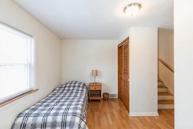 bedroom featuring a closet, visible vents, and light wood-style floors