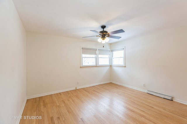 unfurnished room featuring a ceiling fan, baseboards, light wood finished floors, and a baseboard radiator