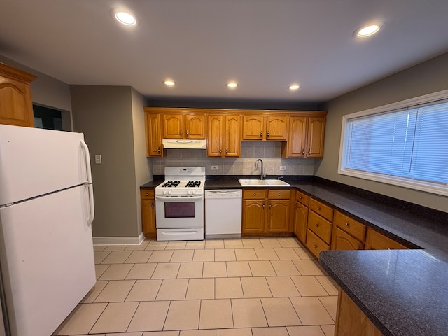 kitchen featuring backsplash, white appliances, and sink