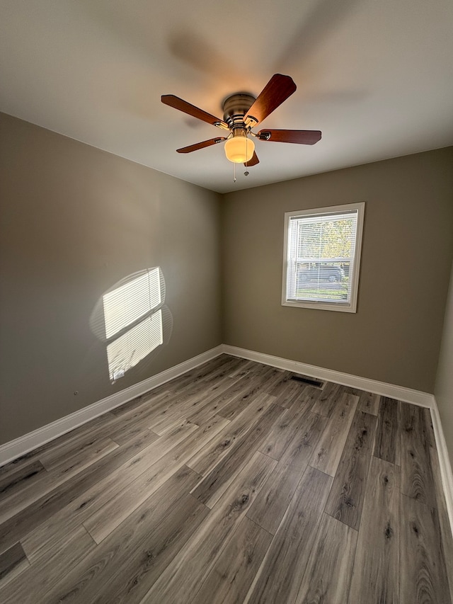 spare room with ceiling fan and wood-type flooring