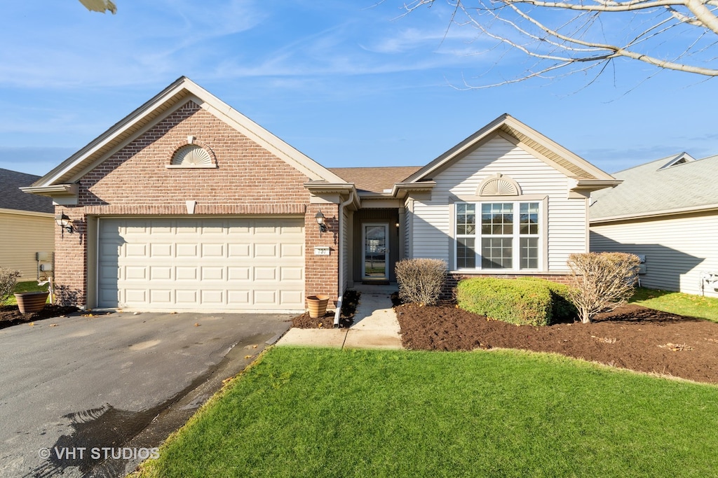 view of front of home with a garage and a front lawn