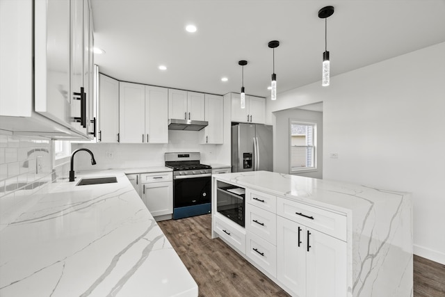 kitchen with white cabinets, hanging light fixtures, light stone counters, dark hardwood / wood-style flooring, and stainless steel appliances