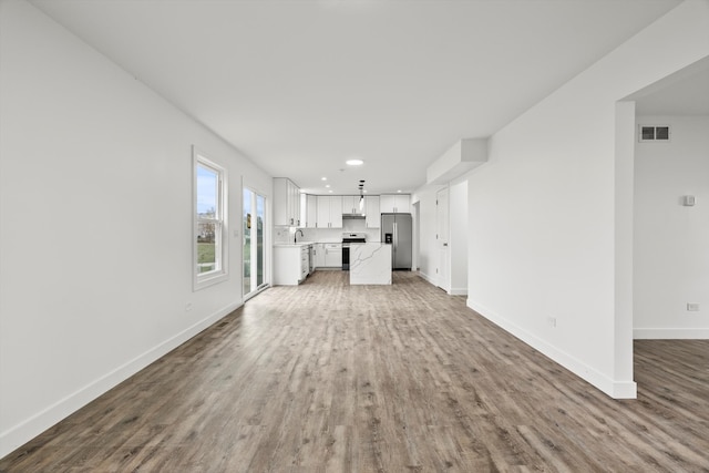 unfurnished living room featuring hardwood / wood-style floors and sink