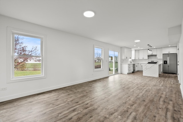 unfurnished living room with hardwood / wood-style floors and sink