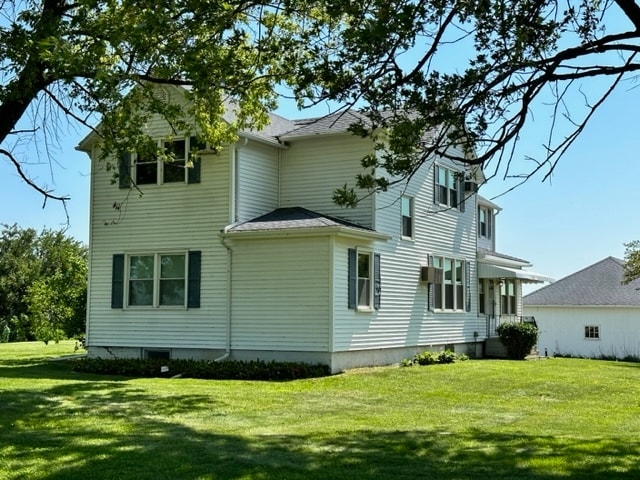 rear view of property featuring a lawn