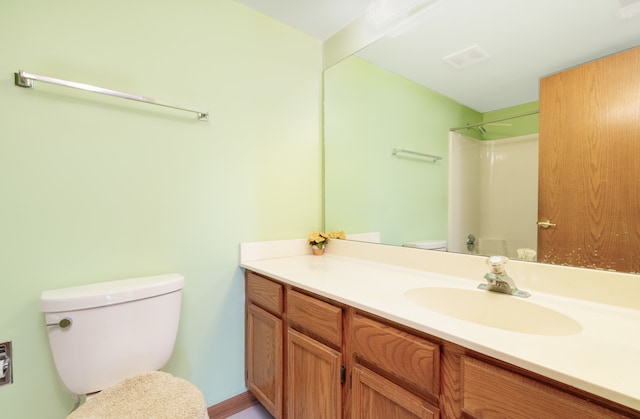 bathroom with vanity, toilet, and walk in shower