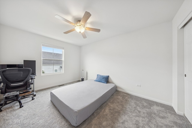 bedroom featuring a closet, light colored carpet, and ceiling fan