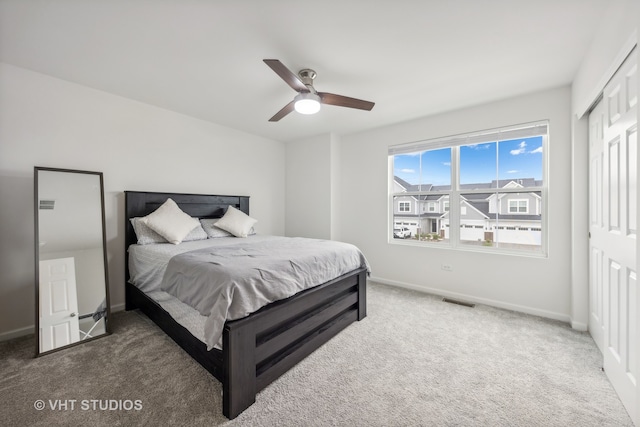 carpeted bedroom with ceiling fan and a closet