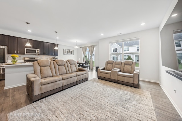 living room with light wood-type flooring and a notable chandelier