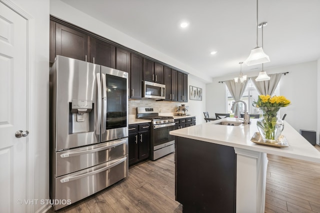 kitchen featuring hardwood / wood-style flooring, decorative light fixtures, sink, and stainless steel appliances