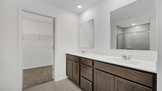 bathroom featuring a shower with door, vanity, and hardwood / wood-style floors