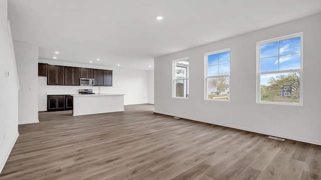 unfurnished living room featuring light hardwood / wood-style floors and sink