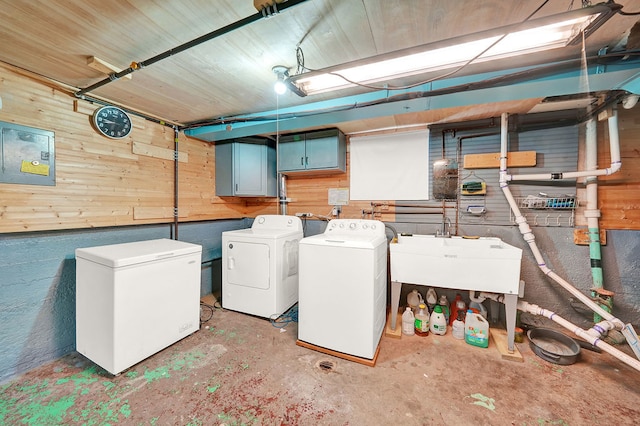 laundry area featuring washer and dryer, sink, and wooden walls