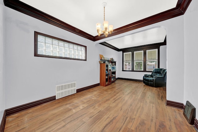 interior space with plenty of natural light, light wood-type flooring, crown molding, and an inviting chandelier