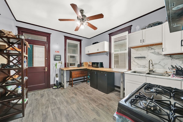 kitchen featuring gas stove, white cabinetry, sink, and light wood-type flooring