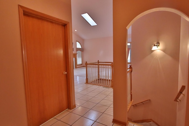 corridor with light tile patterned flooring and a skylight