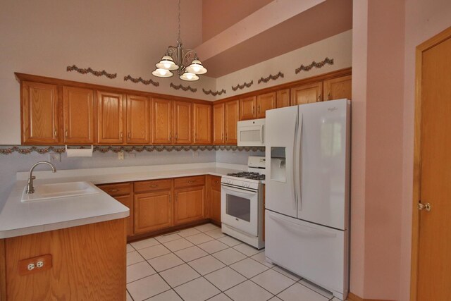 kitchen with white appliances, sink, an inviting chandelier, hanging light fixtures, and light tile patterned flooring