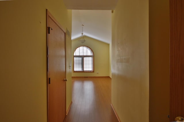 hall with light hardwood / wood-style flooring and lofted ceiling