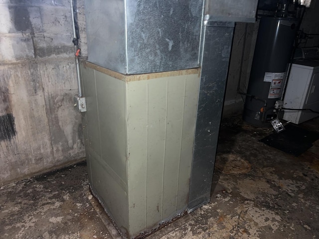 utility room featuring water heater and washer / dryer