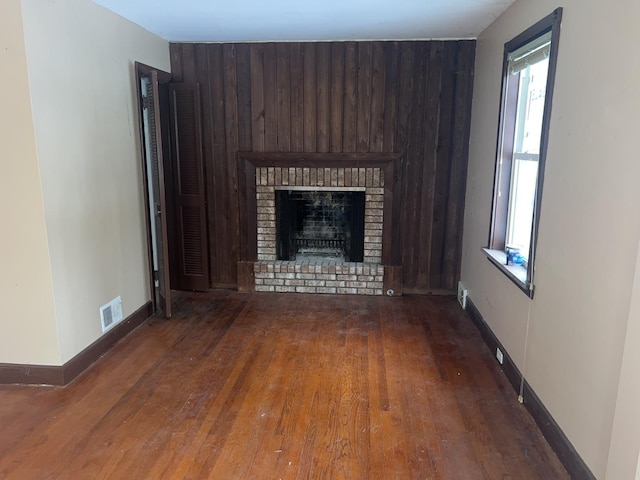 unfurnished living room featuring a fireplace and dark hardwood / wood-style floors