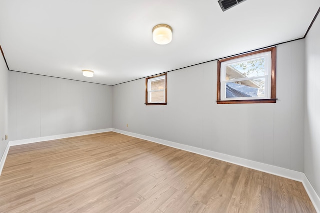 spare room with plenty of natural light and light hardwood / wood-style flooring