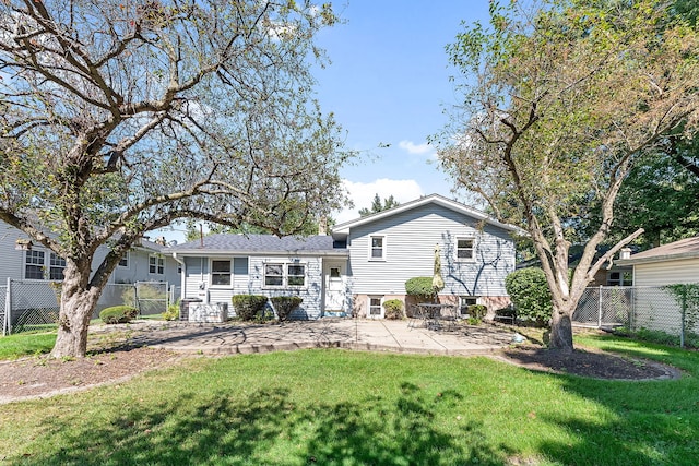 rear view of house with a lawn and a patio