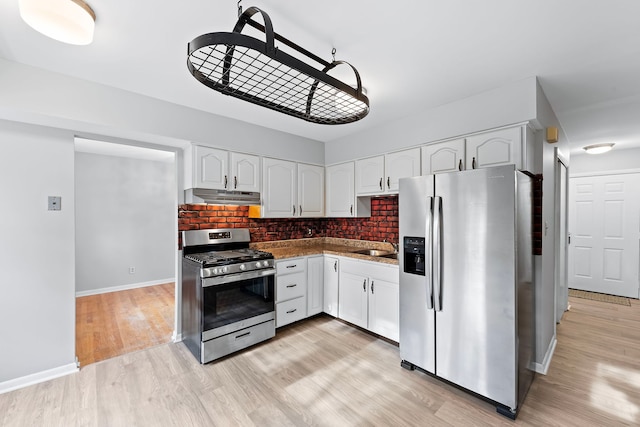 kitchen featuring sink, stainless steel appliances, backsplash, white cabinets, and light wood-type flooring