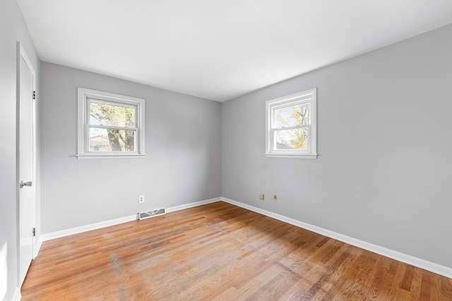 unfurnished room featuring light hardwood / wood-style floors and plenty of natural light