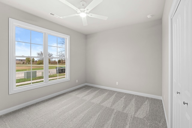 carpeted spare room with ceiling fan