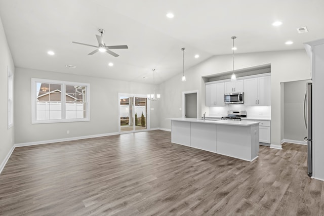 kitchen featuring lofted ceiling, an island with sink, light hardwood / wood-style floors, white cabinetry, and stainless steel appliances