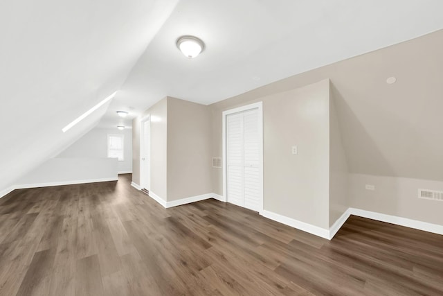 additional living space with vaulted ceiling and dark hardwood / wood-style floors