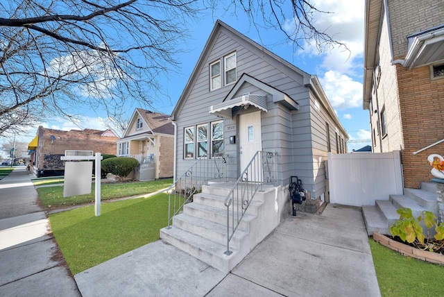 bungalow-style home featuring a front yard and fence