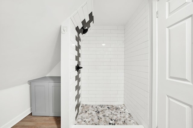 bathroom featuring a tile shower and hardwood / wood-style flooring